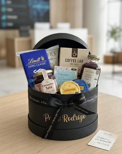 Cesta corporativa personalizada em caixa preta com laço e nome do presenteado em dourado